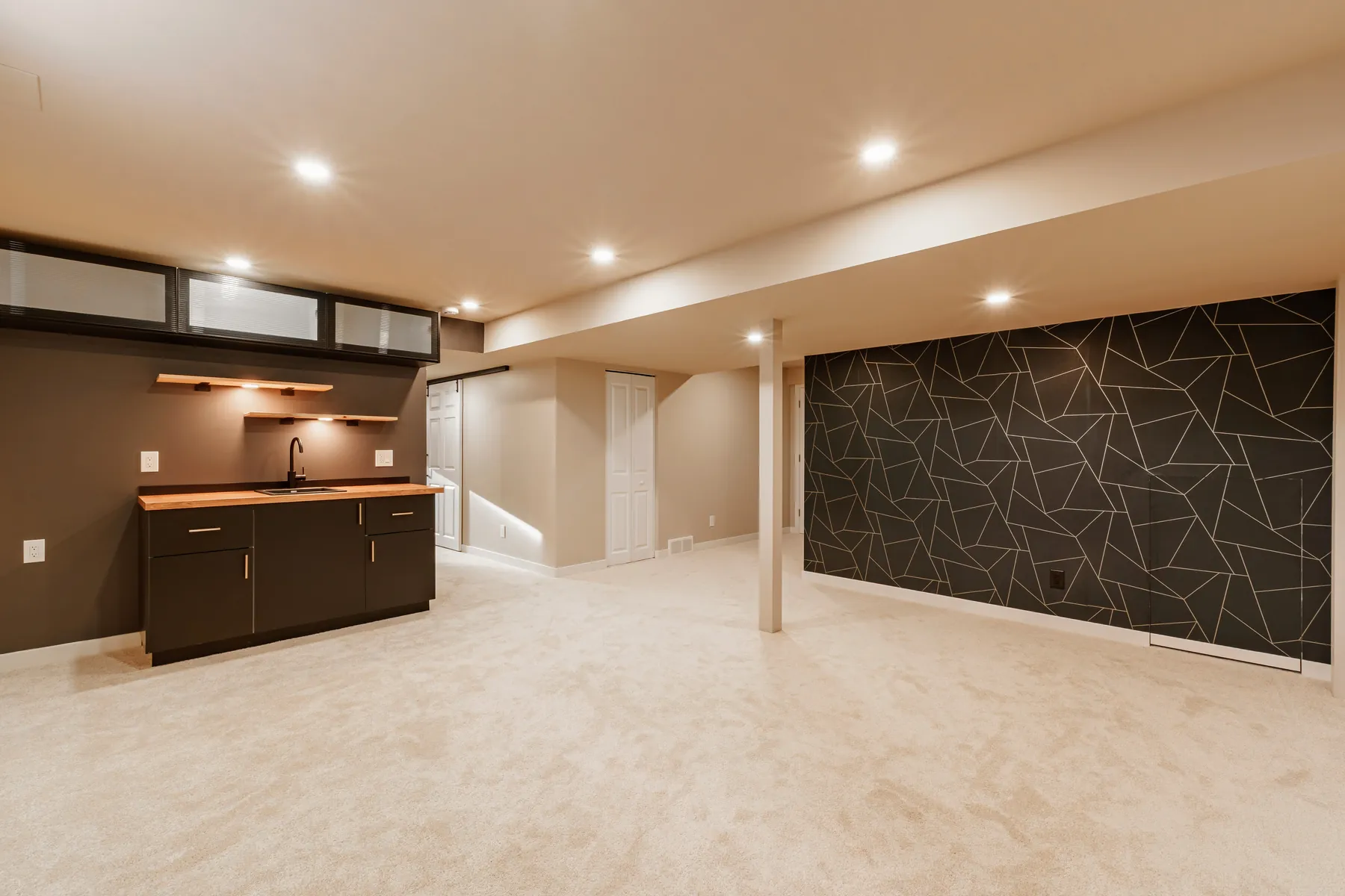 Finished basement with wet bar and feature wall