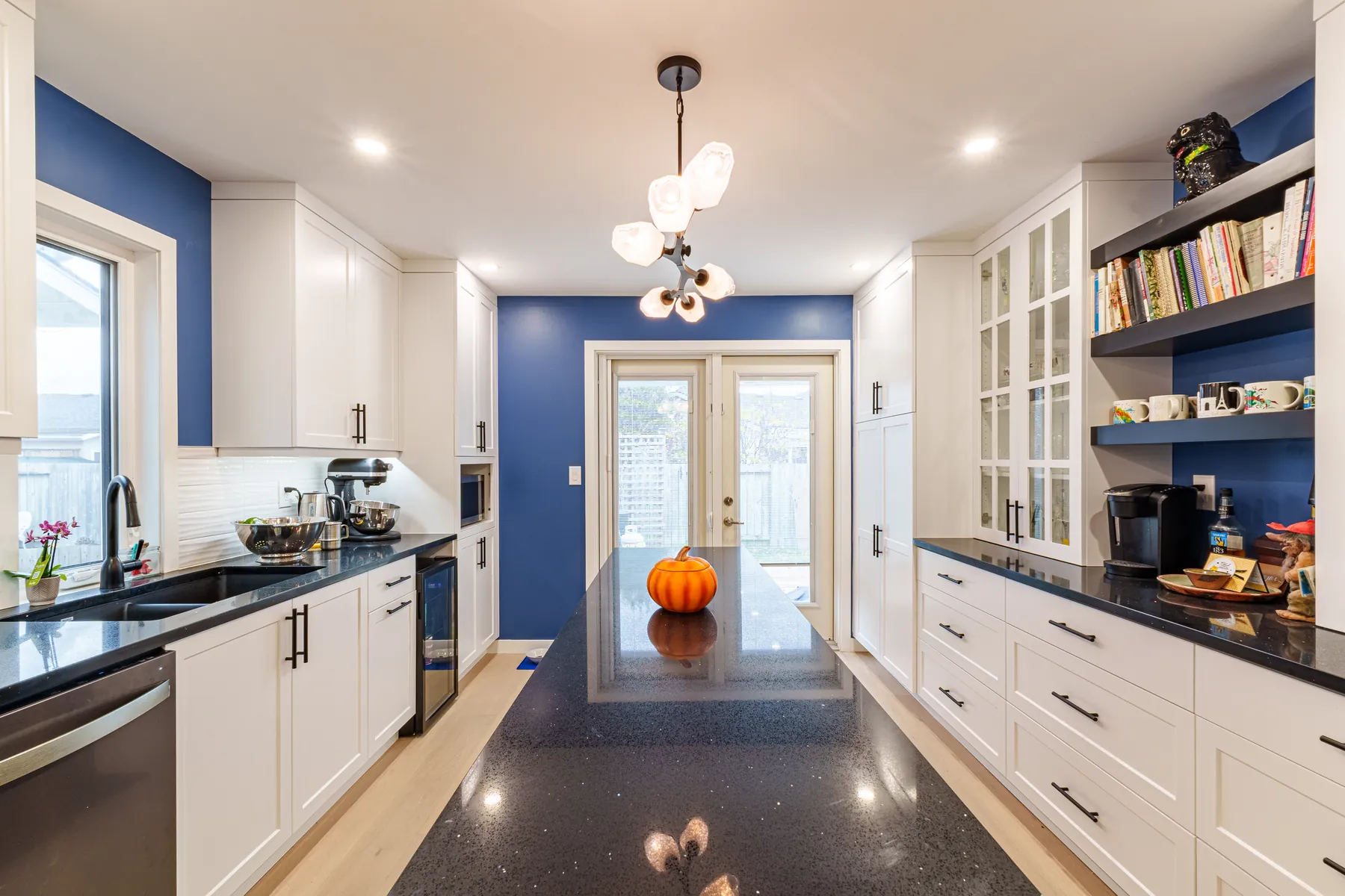Kitchen with navy accent wall and black waterfall island