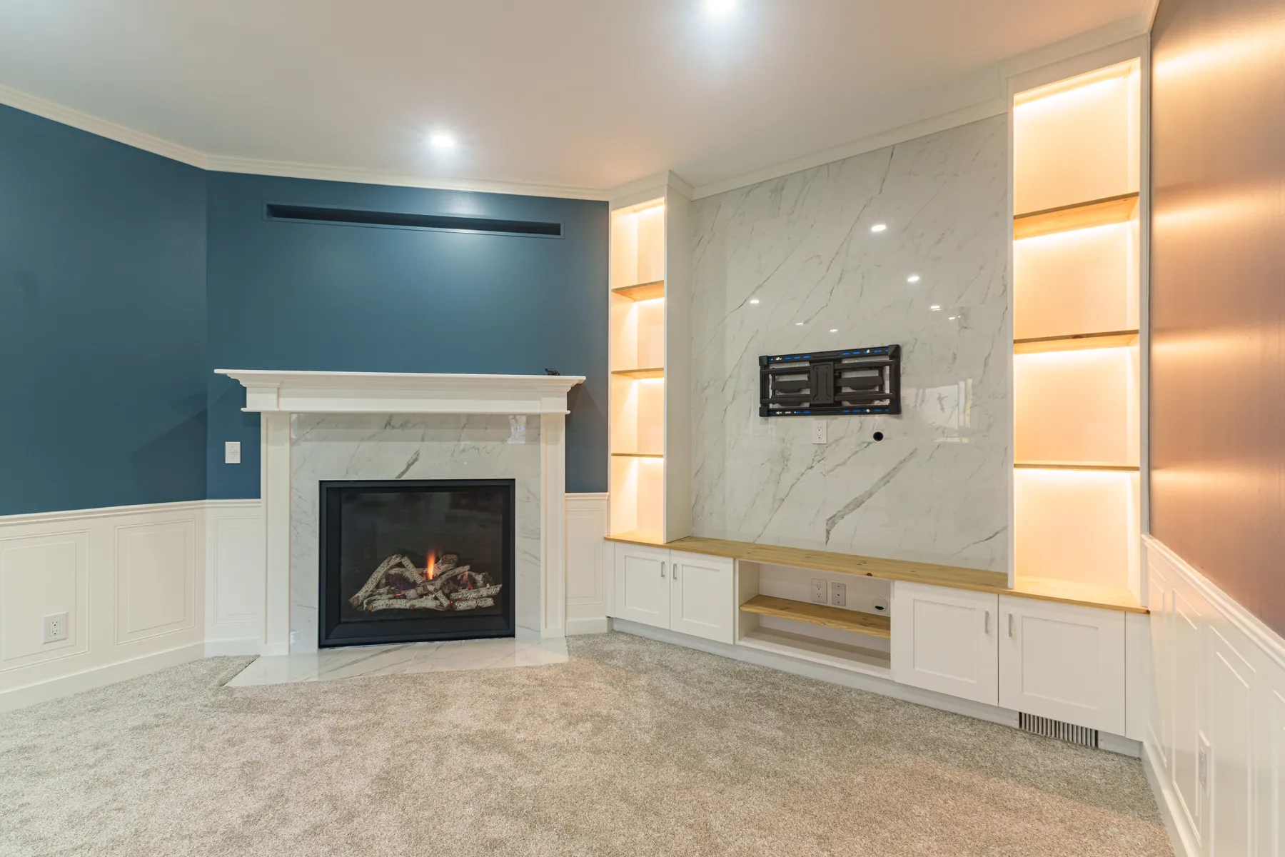 A completed PHS Renovations living room in Winnipeg — navy walls and a marble fireplace surround